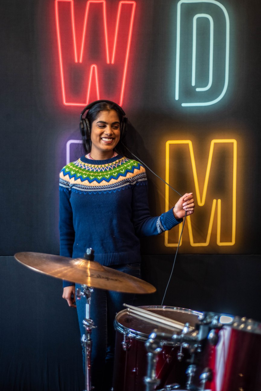 Chelsie Boodoo wearing headphones behind a set of drums