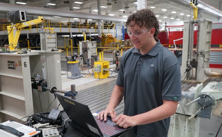 A person working in the auto industry, who is working on a computer.