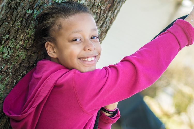 a smiling girl in a pink shirt.