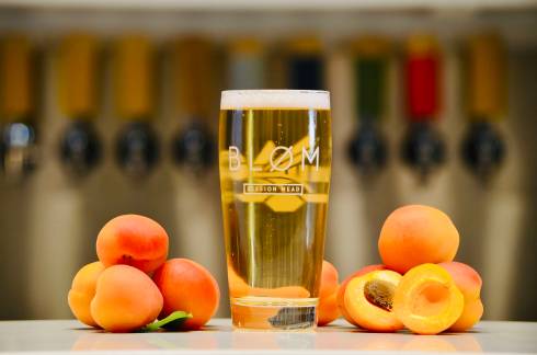 Picture of a full Bløm glass next to fruit.