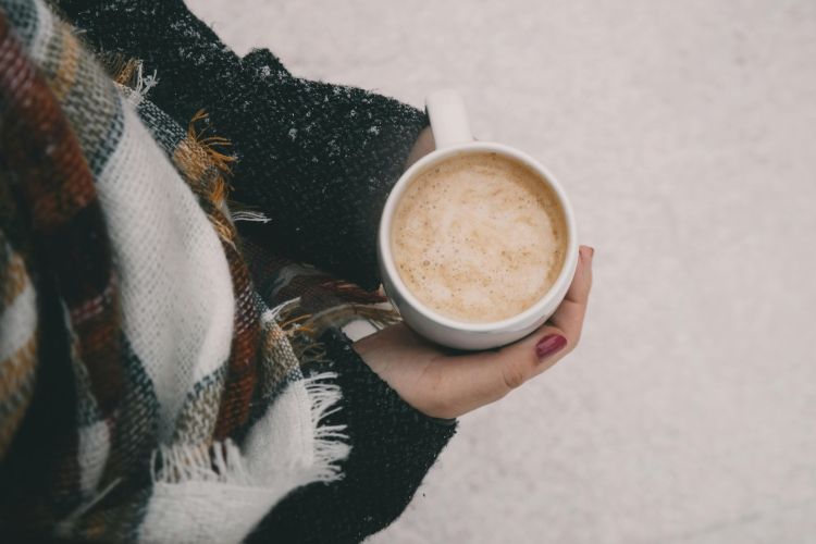 A person holding a cup of coffee.