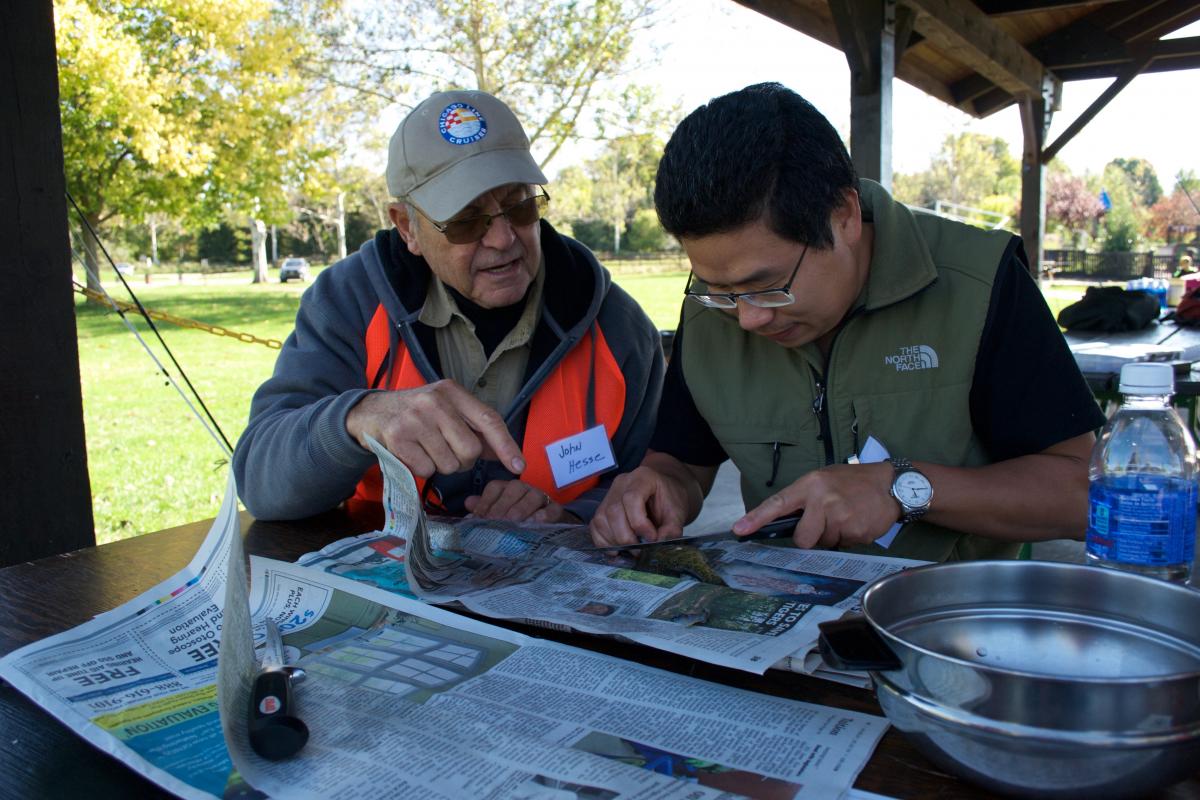 John Hesse helping a student fillet fish