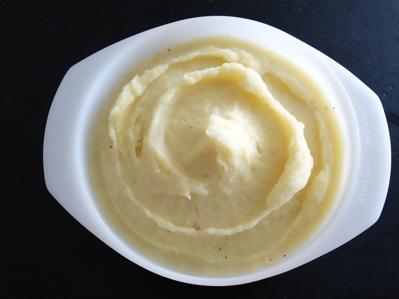 Mashed potatoes in a white bowl.