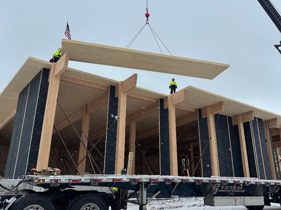 Michigan construction workers using a crane to lift mass timber.