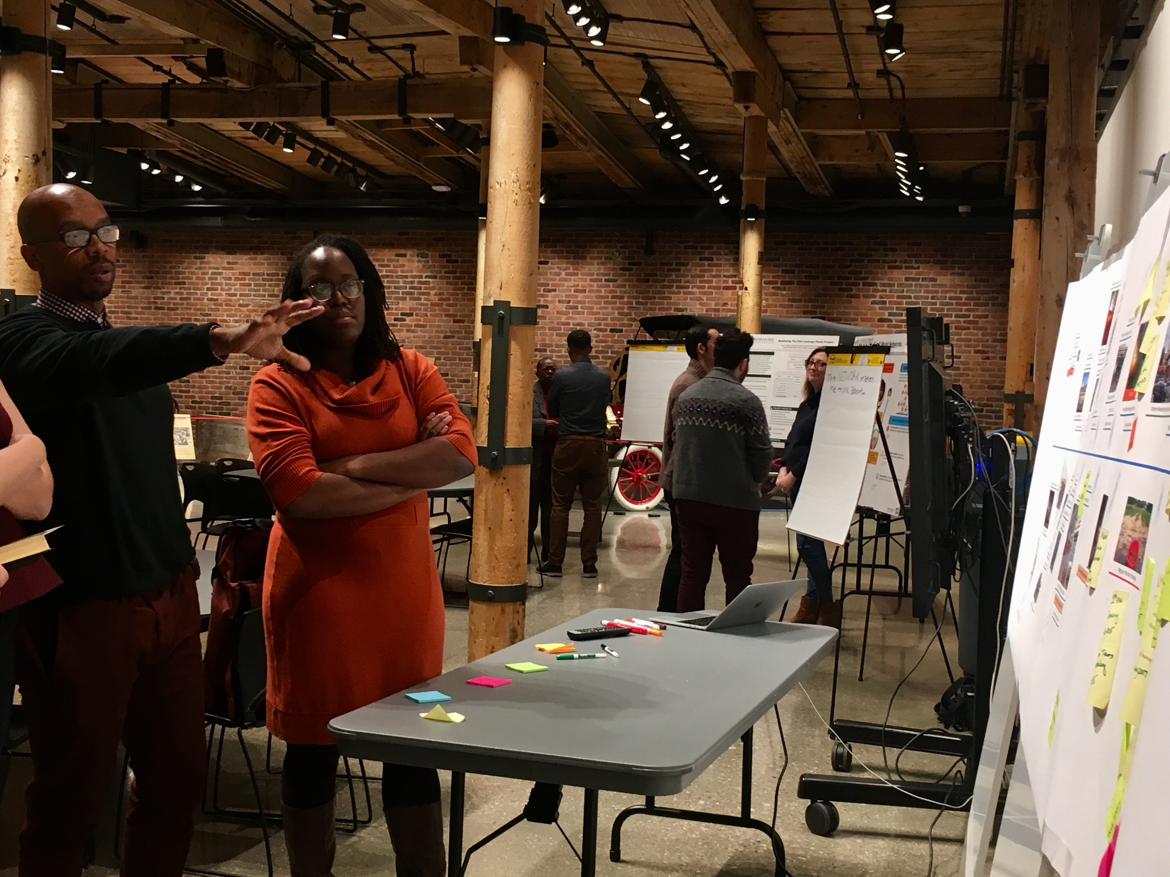 People gathered around flip charts at a community forum in Flint