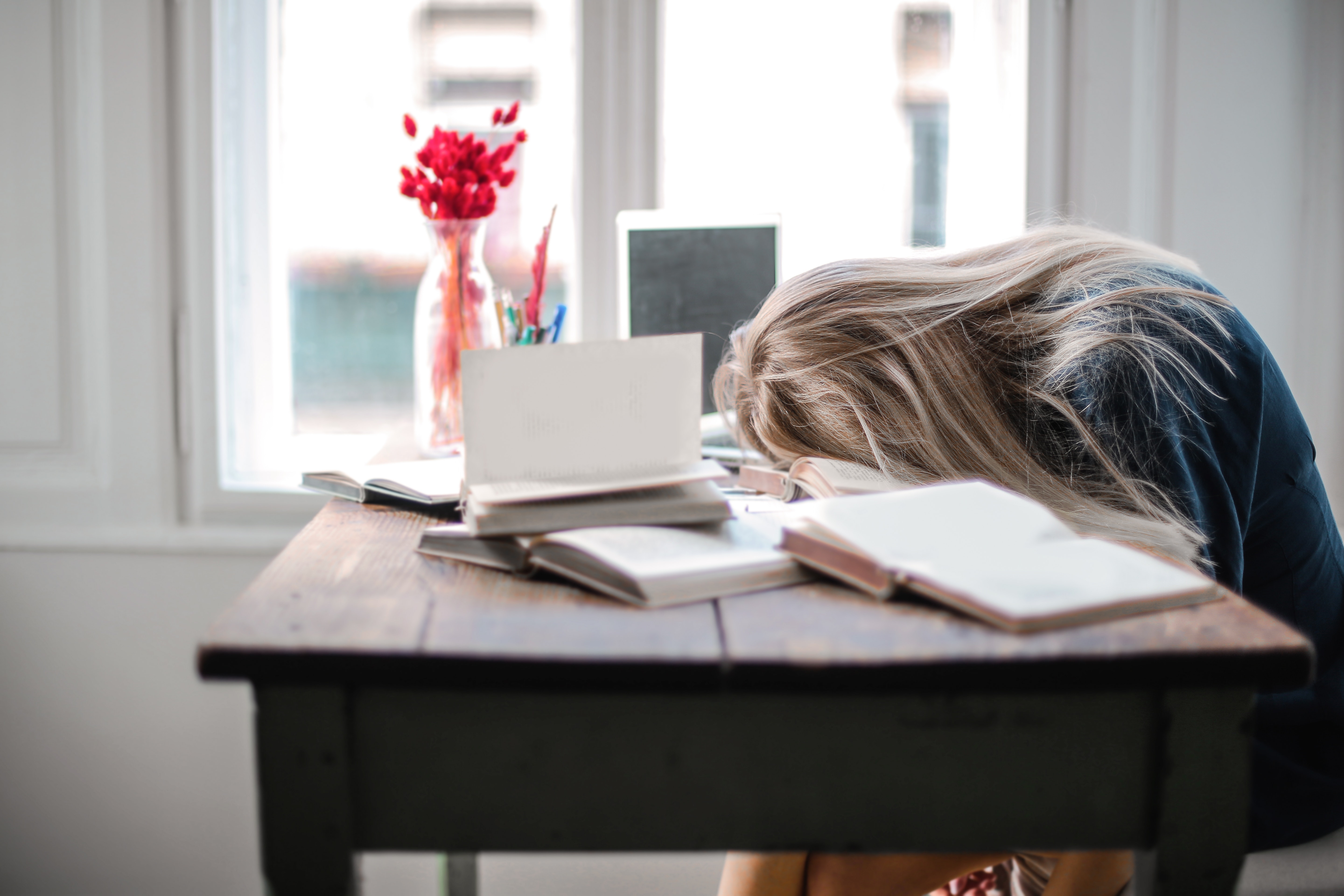 Woman sleeping on book while studying