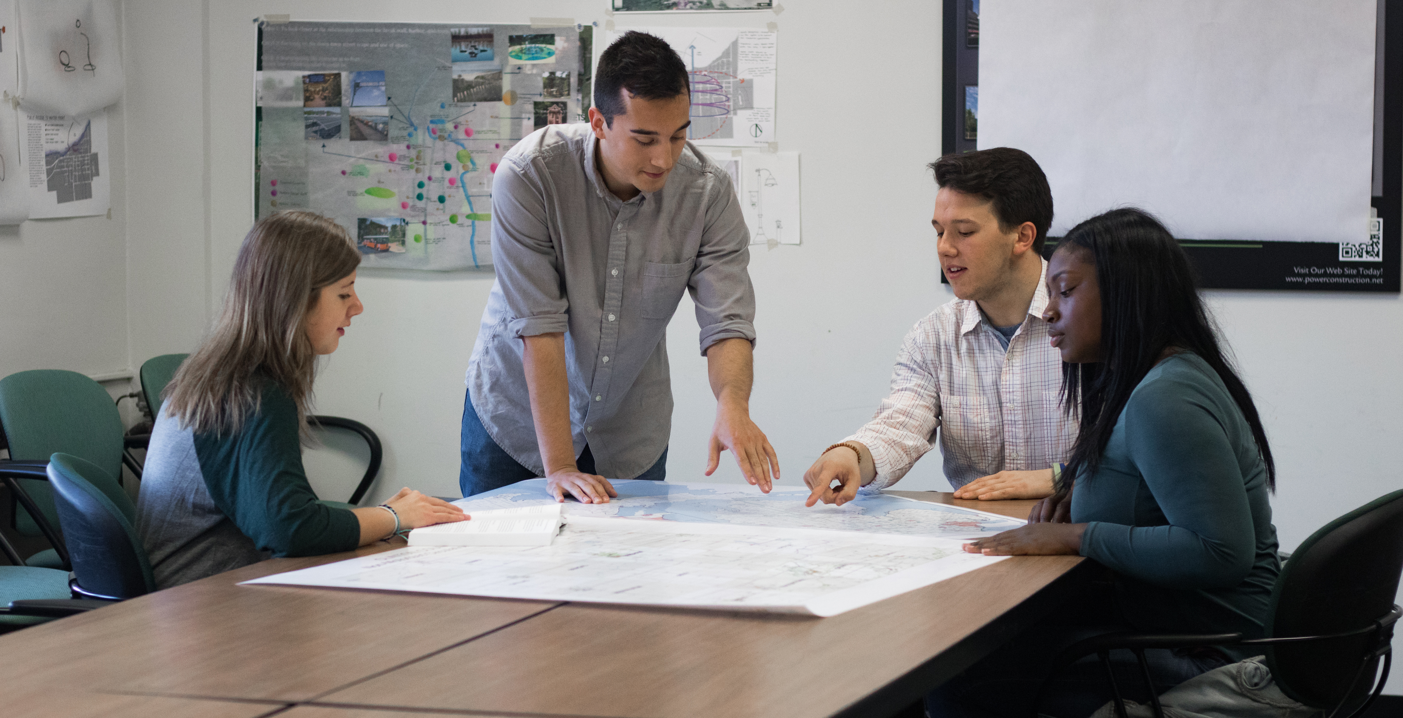 Urban and regional planning graduate students meeting and discussing plan documents.