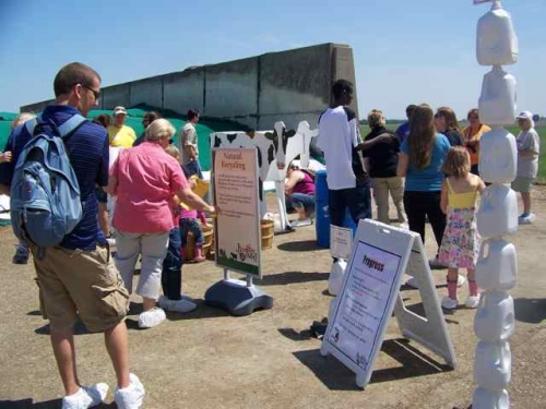 Participants reading educational signs on Progress and Natural recycling